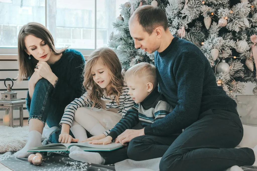 Family reading together in a clean living room beside a Christmas tree